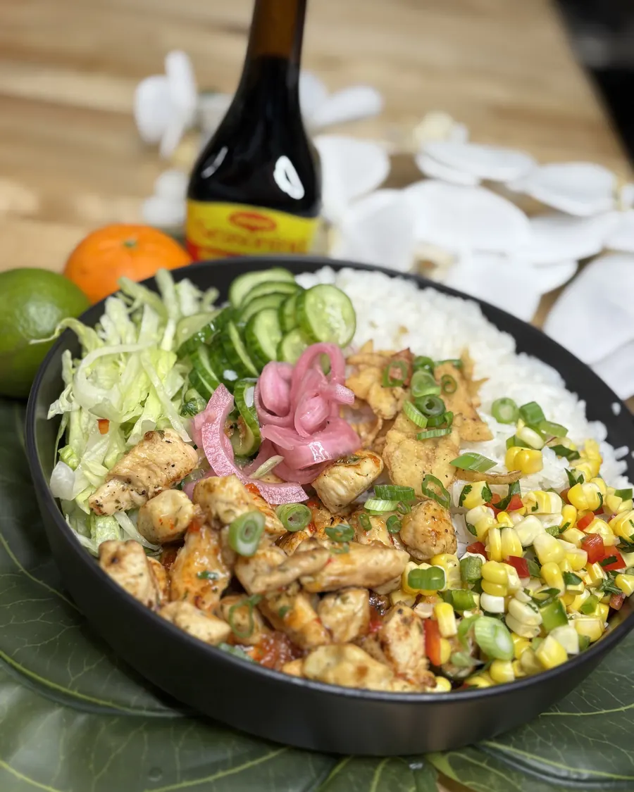 Chicken bowl over rice with corn salsa, pickled red onion, cucumber and cabbage
